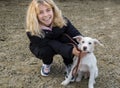 Portrait of happy teenage girl 16-17 years old playing with her white dog outdoors Royalty Free Stock Photo