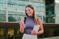 Portrait of a happy teenager female smiling and typing on a smart phone using a social media app outdoors. Young woman Royalty Free Stock Photo