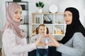 Portrait of happy three generations of islamic women pose together show love heart hand gesture Royalty Free Stock Photo