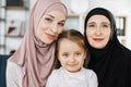 Portrait of happy three generations of muslim women hug and cuddle posing at home Royalty Free Stock Photo