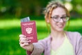 Portrait of happy tourist woman with dreadlocks holding passport and coffee on holiday