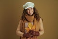Portrait of happy trendy housewife in scarf on brown background Royalty Free Stock Photo