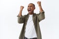 Portrait of happy, triumphing african-american man celebrating victory, football fan winning bet in sports game, raising Royalty Free Stock Photo