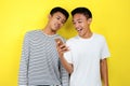 Portrait of happy two casual men smiling look at smartphone. Portrait of handsome two young men looking at their phone and smiling Royalty Free Stock Photo