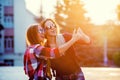 Portrait of a happy two smiling girls making selfie photo on smartphone. urban background. The evening sunset over the Royalty Free Stock Photo