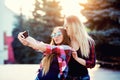 Portrait of a happy two smiling girls making selfie photo on smartphone. urban background. The evening sunset over the Royalty Free Stock Photo