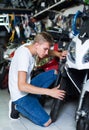 Portrait of male motorcyclist looking on the bike in the store