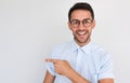 Portrait of happy unshaven handsome male smiling with toothy smile, points aside, looking to the camera, shows copy space for your Royalty Free Stock Photo