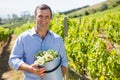 Portrait of happy vintner holding harvested grapes in bucket Royalty Free Stock Photo