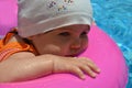 Portrait of happy white Caucasian child baby girl toddler in swimming pool outdoor. Preschool boy training to float with Royalty Free Stock Photo