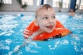 White Caucasian child in swimming pool. Preschool boy training to float with red circle ring in water Royalty Free Stock Photo