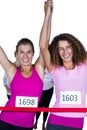 Portrait of happy winner athletes crossing finish line with arms raised Royalty Free Stock Photo