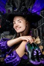 Portrait of a happy witch in a suit with shoes on a black