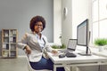 Portrait of a happy, smiling woman accountant sitting at her working desk with computers Royalty Free Stock Photo