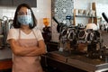 Portrait of a happy woman Asian waitress wearing a face mask and  standing at a coffee shop, Small business owner and startup with Royalty Free Stock Photo