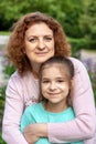 Portrait of a happy woman and daughter smiling and looking at the camera. Royalty Free Stock Photo