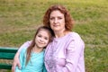 Portrait of a happy woman and daughter smiling and looking at the camera. Royalty Free Stock Photo