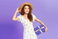 Portrait of a happy woman in dress and summer hat holding present box isolated over blue background Royalty Free Stock Photo