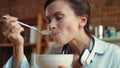 Woman eating cornflaces with milk in kitchen. Girl enjoying cereal for breakfast Royalty Free Stock Photo