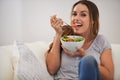 Portrait, happy woman and eating a salad on couch, lunch and healthy food for nutrition in home. Smile, face and young Royalty Free Stock Photo