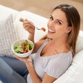 Portrait, happy woman and eating salad on sofa for lunch and healthy food for nutrition in home. Smile, face and young Royalty Free Stock Photo