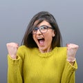 Portrait of happy woman exults pumping fists ecstatic celebrates success against gray background Royalty Free Stock Photo