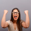 Portrait of happy woman exults pumping fists ecstatic celebrates success against gray background Royalty Free Stock Photo