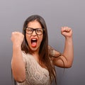 Portrait of happy woman exults pumping fists ecstatic celebrates success against gray background Royalty Free Stock Photo