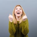 Portrait of happy woman exults pumping fists ecstatic celebrates success against gray background Royalty Free Stock Photo