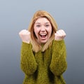 Portrait of happy woman exults pumping fists ecstatic celebrates success against gray background Royalty Free Stock Photo