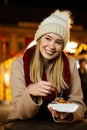 Portrait of happy woman girl eating donuts and enjoying christmas market. Holiday christmas people Royalty Free Stock Photo