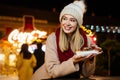 Portrait of happy woman girl eating donuts and enjoying christmas market. Holiday christmas people Royalty Free Stock Photo