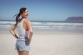 Portrait of happy woman with hands on hip standing at beach Royalty Free Stock Photo