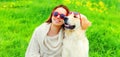 Portrait of happy woman with her Golden Retriever dog wearing sunglasses on green grass in summer park Royalty Free Stock Photo