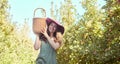 Portrait of a happy woman holding basket, picking fresh apples from a tree on sustainable orchard farm outside on sunny Royalty Free Stock Photo