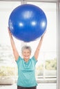 Portrait of happy woman holding blue exercise ball Royalty Free Stock Photo