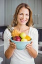 Portrait of happy woman holding fruit bowl Royalty Free Stock Photo