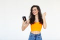 Portrait of a happy woman holding mobile phone and celebrating a win isolated over white background Royalty Free Stock Photo