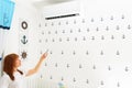 Happy Young Woman Holding Remote Control Relaxing Under The Air Conditioner. Royalty Free Stock Photo