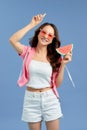 Portrait happy woman is holding slice of watermelon over colorful blue background Royalty Free Stock Photo
