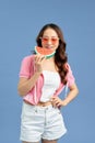 Portrait happy woman is holding slice of watermelon over colorful blue background Royalty Free Stock Photo