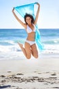 Portrait, happy woman and jump with scarf at beach in wind outdoor for summer, vacation and travel on holiday. Ocean Royalty Free Stock Photo