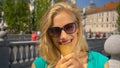 PORTRAIT: Happy woman looks at the camera while eating chocolate ice cream. Royalty Free Stock Photo