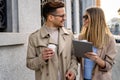 Portrait of happy woman and man walking on the street with coffee, digital tablet and having fun.