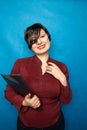 Portrait of happy woman in office, standing with folder on bluw studio background Royalty Free Stock Photo