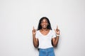 Portrait of a happy woman pointing up and smiling against white background