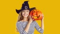 Portrait of a happy beautiful young woman in a witch hat with a Halloween pumpkin Royalty Free Stock Photo