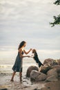 Image of happy woman 20s hugging her dog while walking along the beach Royalty Free Stock Photo