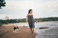 Image of happy woman 20s hugging her dog while walking along the beach Royalty Free Stock Photo