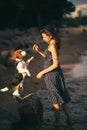 Image of happy woman 20s hugging her dog while walking along the beach Royalty Free Stock Photo